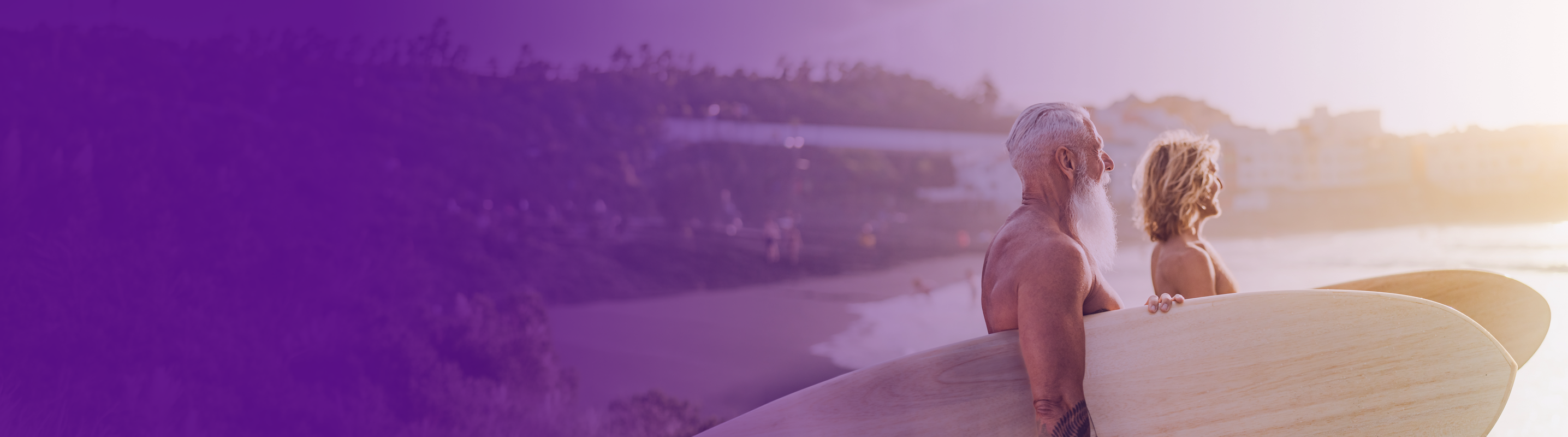 couple holding surfboards getting ready to surf on the beach